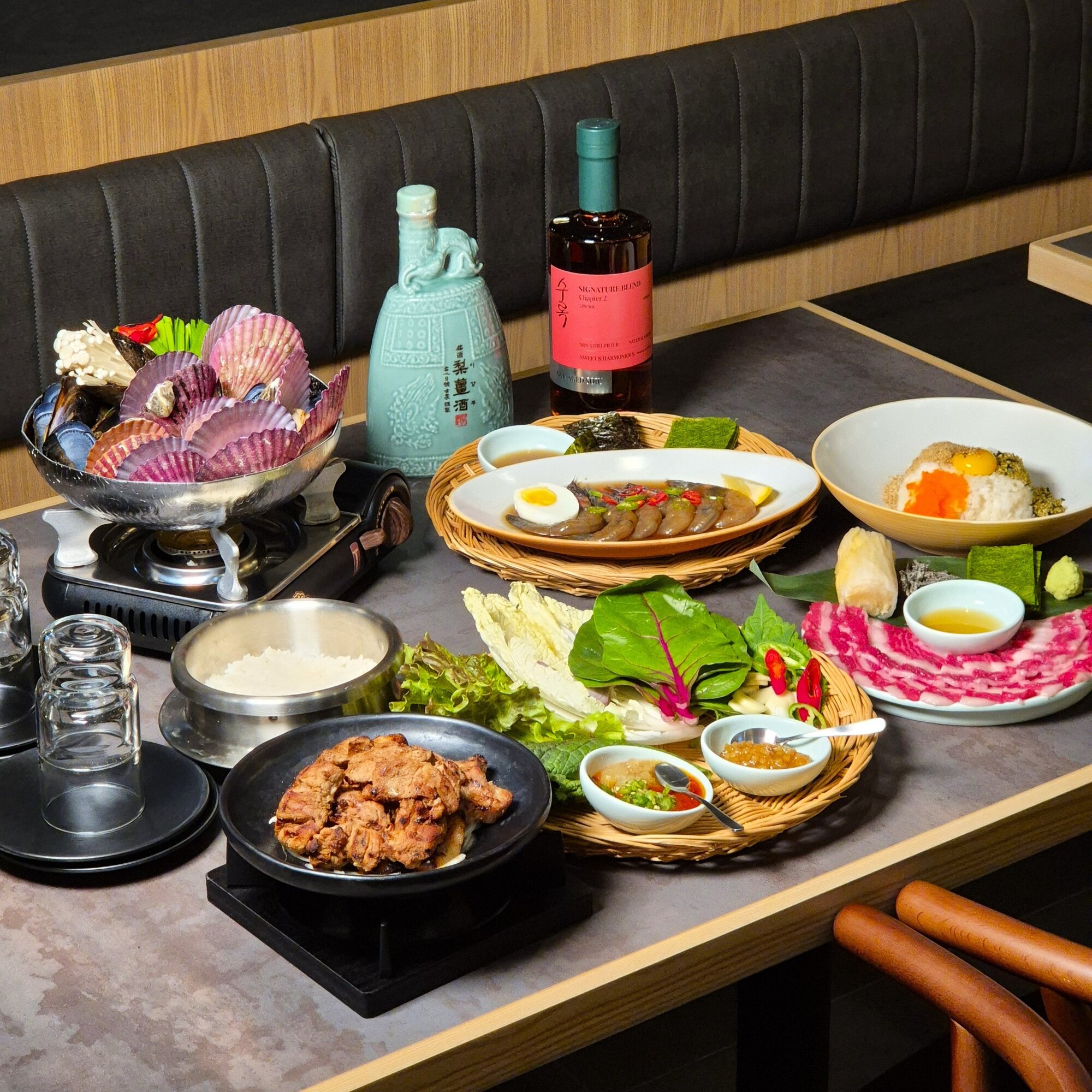 조개전골과 육회, 고기, 전통주가 함께 차려진 무월의 풍성한 한 상